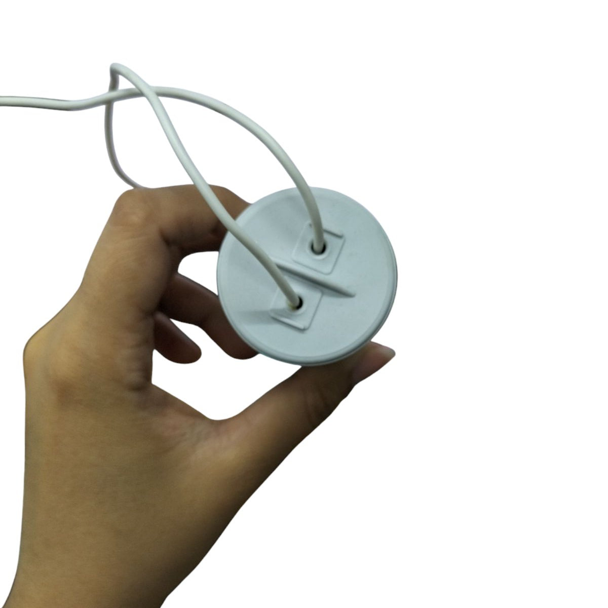 Hand holding a Syscap Motor Running Capacitor 33MFD with two white wires for electrical circuitry