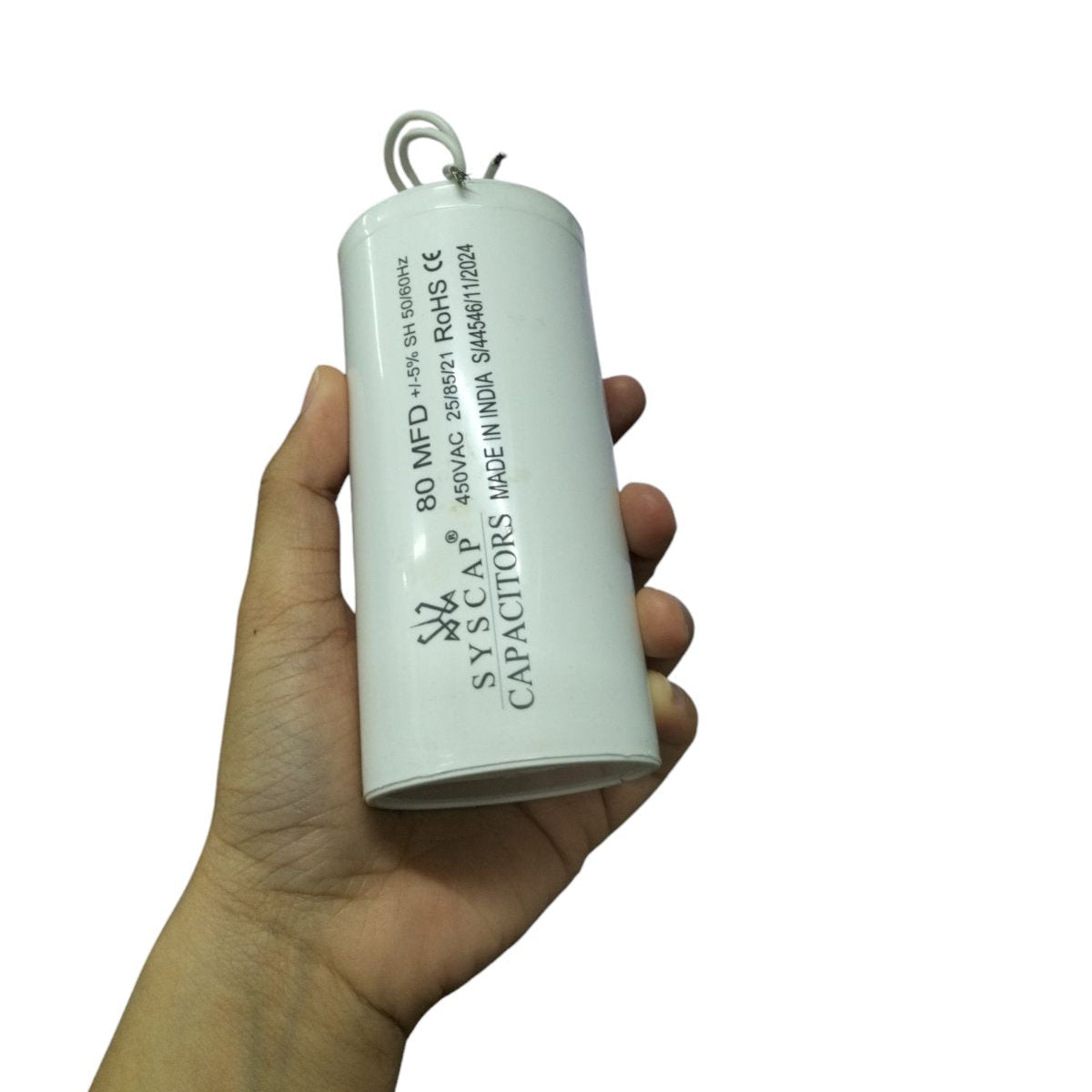 Hand holding SYSCAP Motor Running Capacitor 80MFD 450V AC electrical component for motors